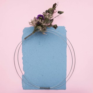 Empty decorative frame made with metallic cable flower bouquet paper pink background