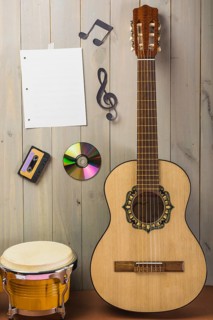 Blank musical page cassette compact disc musical note stuck wooden wall with guitar bongo drum