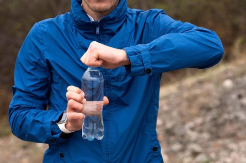 Man holding bottle water nature