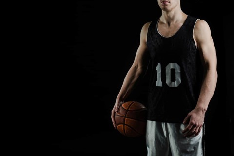 Professional basketball player holding ball his arm