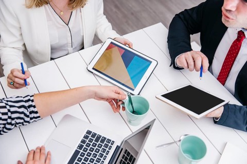 Crop businesspeople with gadgets desk
