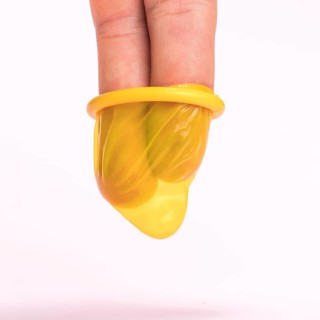 Close up fingers yellow condom