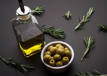 Olives olive oil rosemary black slate surface