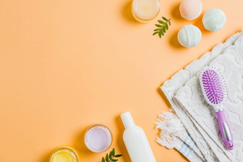 Towel moisturizers hairbrush bath bomb colored background