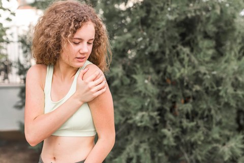 Close up female athlete having pain shoulder