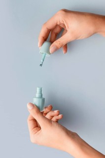 Close up hands holding blue nail polish