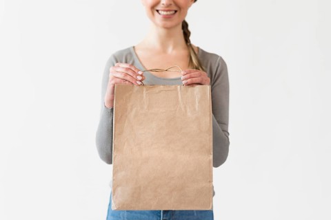 Close up woman holding paper bag with groceries