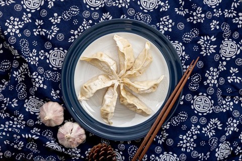 Dim sum white plate with garlic floral blue background