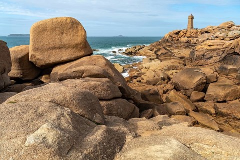 The rocks of the pink granite coast Cote de Granit Rose and the lighthouse Phare de Ploumanac'h near Ploumanac'h