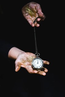 Man with glitters showing pocket watch