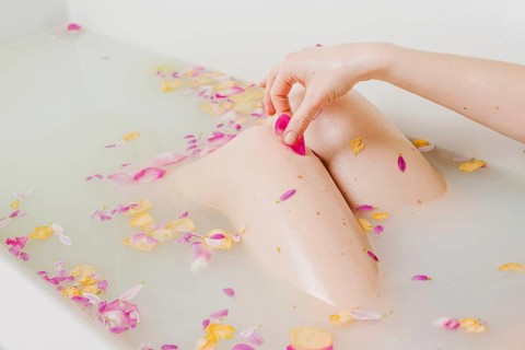 Woman relaxing bath with flowers