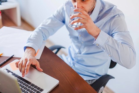Man drinking water sitting table