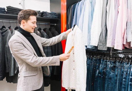 Young man shop checking price tag shirt