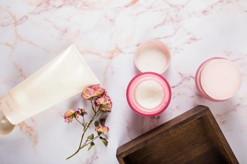 Moisturizing cream with flowers marble background
