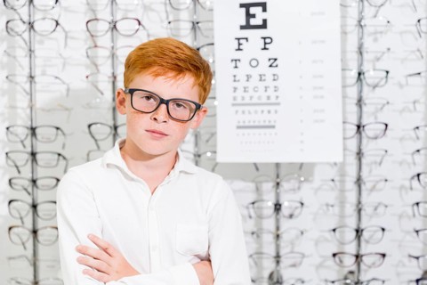 Portrait innocent boy with arm crossed posing optics store