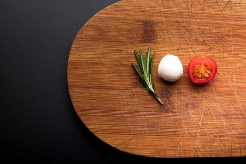 Close up fresh cheese rosemary half tomato chopping board