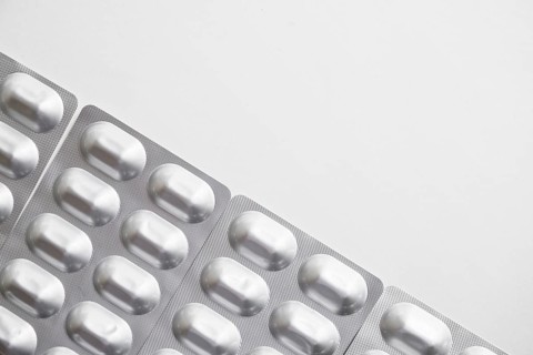 Overhead view silver pills blister pack white background
