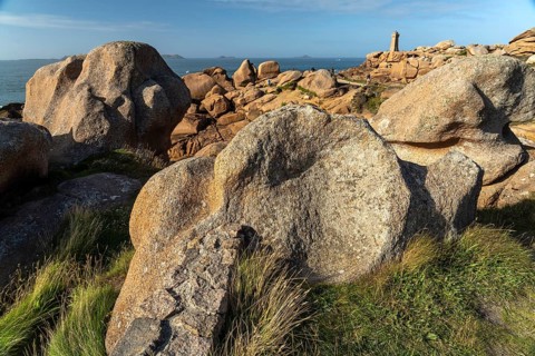 The rocks of the pink granite coast Cote de Granit Rose and the lighthouse Phare de Ploumanac'h near Ploumanac'h