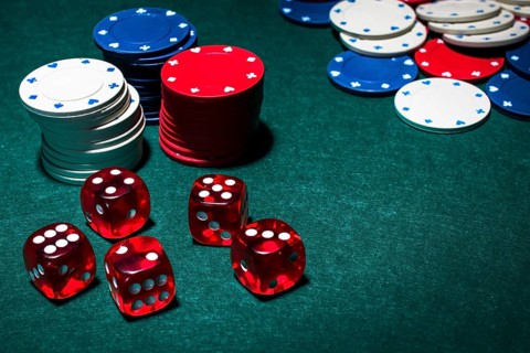 Red dices stack gambling chips green poker table