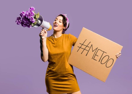 Woman talking megaphone holding cardboard with me too sign