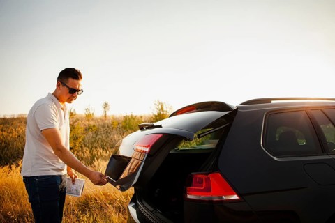 Young man opening trunk