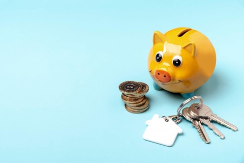 Yellow piggy bank with keys copy space background