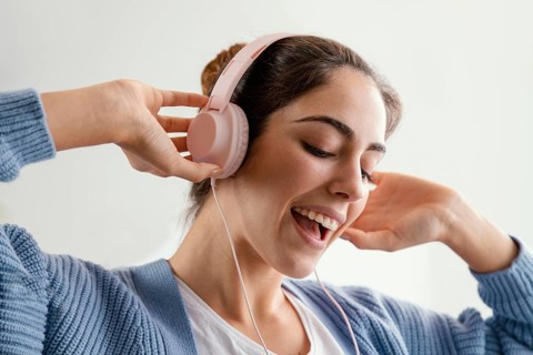 Smiley woman listening music headphones