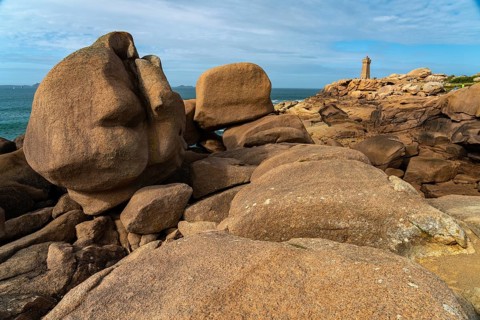 The rocks of the pink granite coast Cote de Granit Rose and the lighthouse Phare de Ploumanac'h near Ploumanac'h