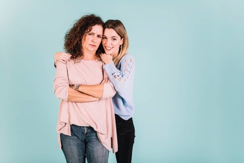 Woman embracing displeased mother