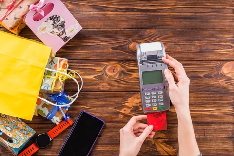 Human hands using credit card swiping machine payment store