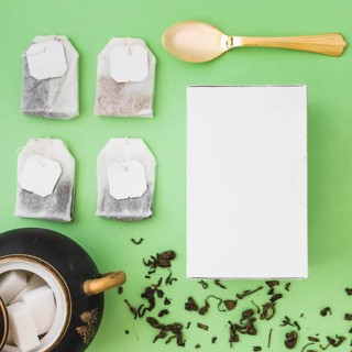 Different type herbal tea bags sugar cubes spoon white box colored background
