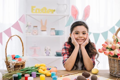 Portrait girl with easter eggs paint tulips flowers table