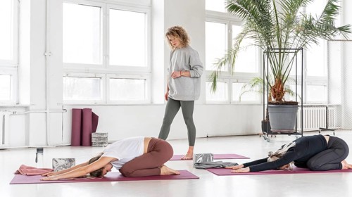 Teacher watching women stretching