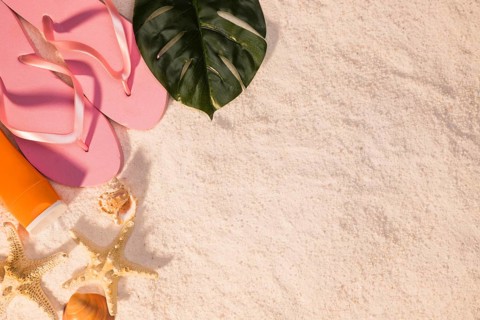 Beach concept with pink flip flops