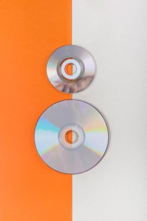 Overhead view compact discs orange white dual background