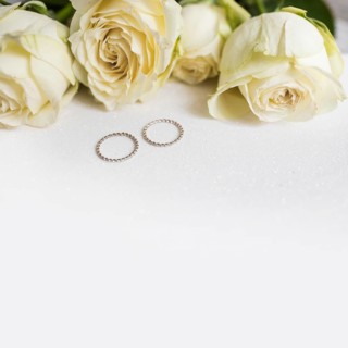 Wedding rings fresh roses white background