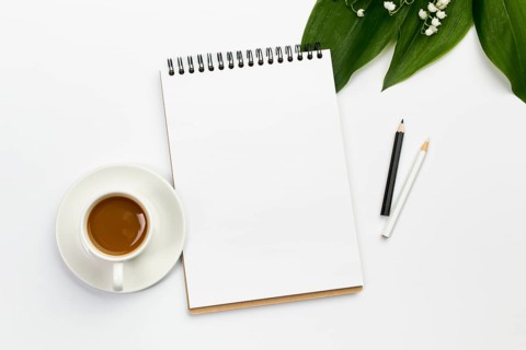 Coffee cup blank spiral notepad colored pencils with leaves flower office desk