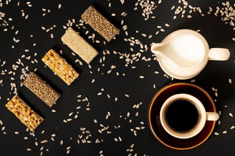 Flat lay cereal bars assortment with milk coffee plain background