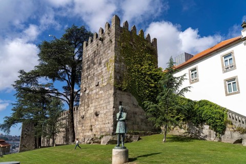 Statue of Arnaldo Gama in front of the tower of the historic city wall in Porto