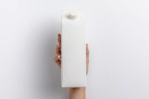 Front view hand holding simple milk carton