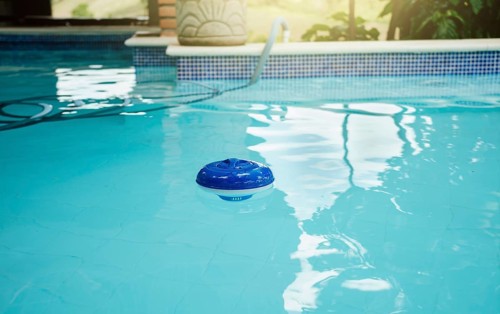 Chlorine dispenser in a beautiful swimming pool. A chlorine float in a swimming pool. Dosing float for swimming pool chlorination