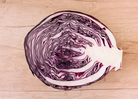 Halved red cabbage wooden background