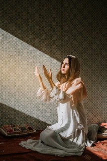 Muslim woman praying with sunlight effect
