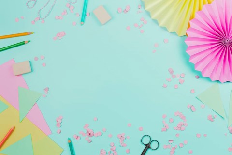 Circular paper fan with confetti colored pencils teal background