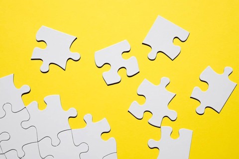 Separate white puzzle piece yellow backdrop