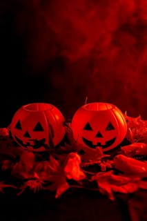 Halloween pumpkins on autumn leaves with smoke on a red background