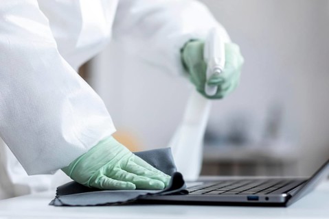 Person disinfecting dangerous area while wearing protective suit