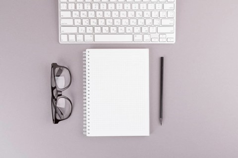 Pencil near notebook keyboard eyeglasses