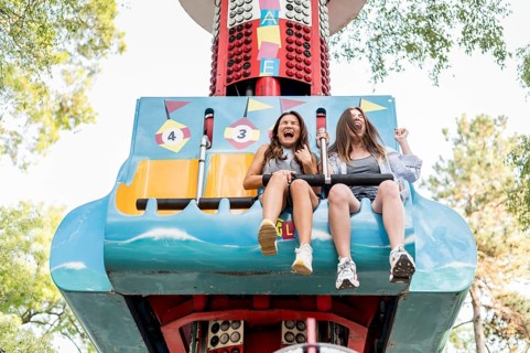 Smiley female friends having fun amusement park