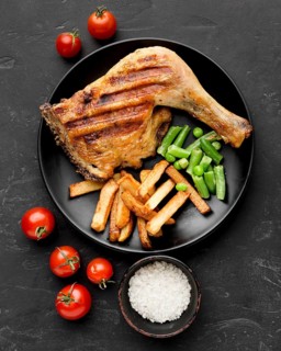 Top view baked chicken potatoes plate with tomatoes